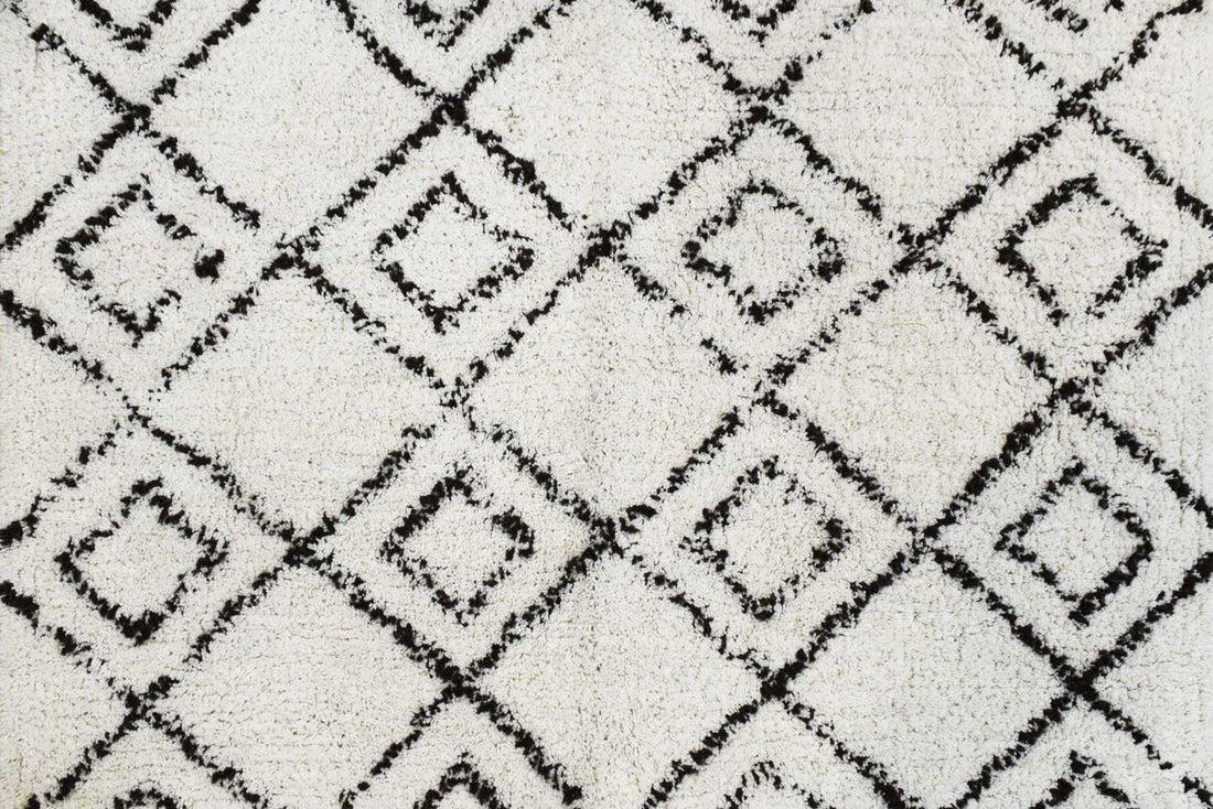 Detalle del tapete IC8703: textura tufted clara con líneas geométricas negras