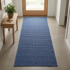 Alfombra azul marino en una entrada luminosa con puerta de madera clara