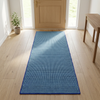 Alfombra de 60 × 180 cm centrada en una entrada luminosa con puerta de madera clara