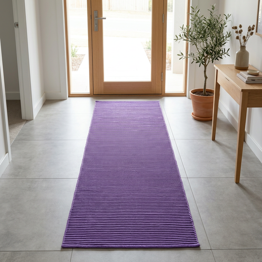 Alfombra morada en una entrada luminosa con puerta de madera clara