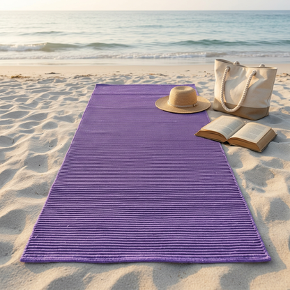 Alfombra morada sobre arena clara en una playa tranquila