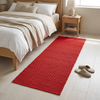 Alfombra roja junto a la cama en un dormitorio acogedor