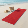 Alfombra roja sobre arena clara en una playa tranquila