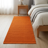 Alfombra naranja IC11139 junto a una cama