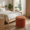 Puf naranja en un dormitorio neutro